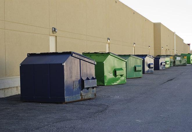 construction workers throw waste into a dumpster behind a building in Hialeah Gardens